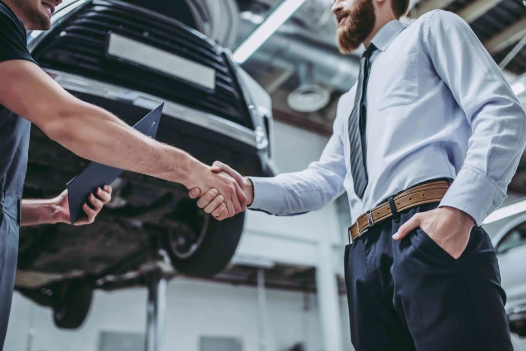 customer shaking hands with auto repair technician